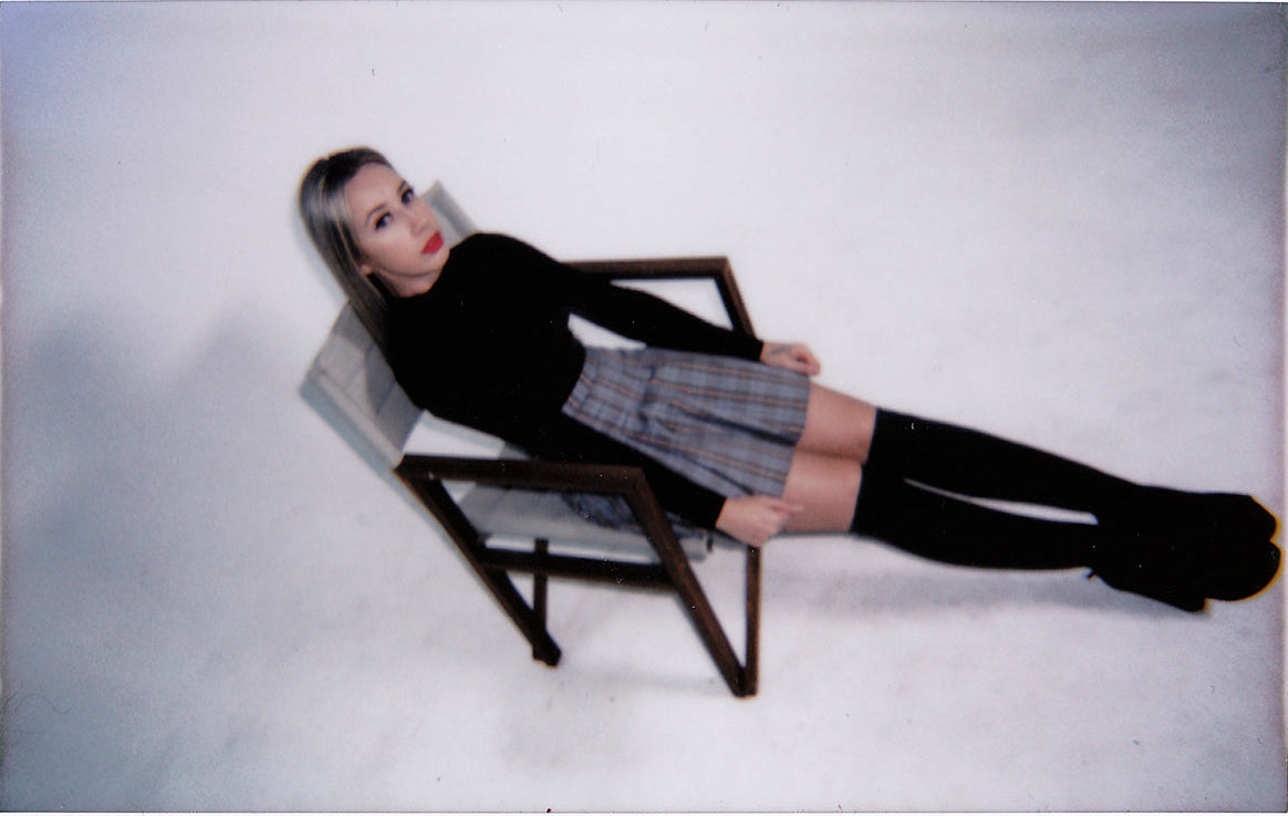 Elisabeth sitting on a chair against a white background